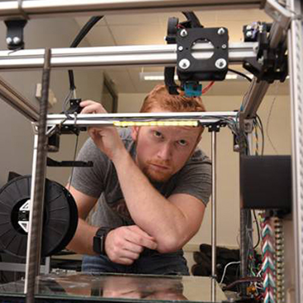Isaac inspects a 3D printer