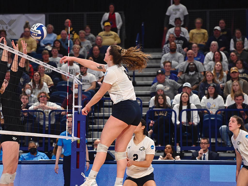 Photo by JD Cavrich Courtney Williams ’25, middle blocker/hitter, executed a quick attack as spectators looked on during the team’s National Championship-winning match.